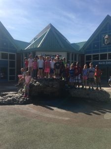 Students on the rock in front of the zoo